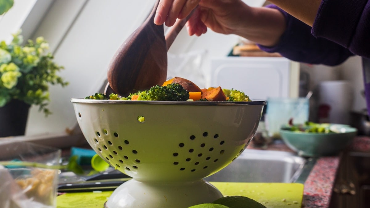 person holding brown wooden ladle